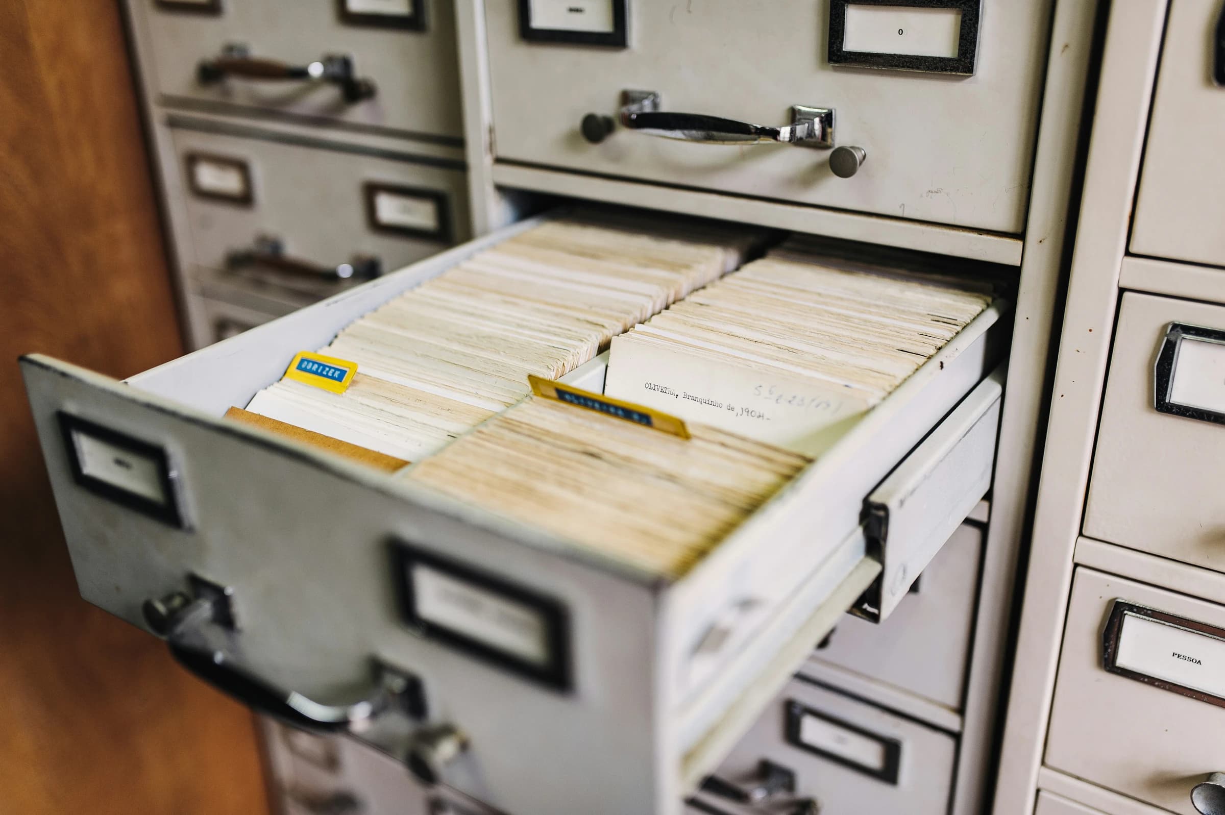 Rows of real tabbed files in an open filing cabinet, with no hands in frame.